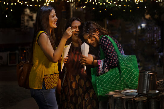 women having fun and eating Jhalmuri on street