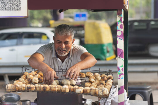 Male vendor making litti at his roadside food stall