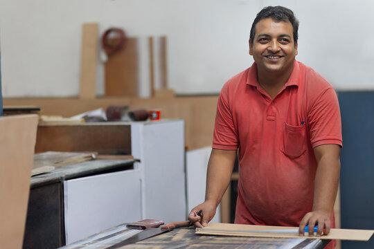 Male carpenter measuring the board