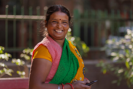 A house maid standing in the colony park using her mobile phone during her resting period 