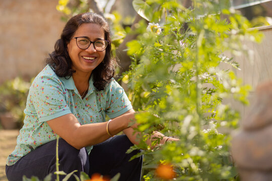 Portrait of happy senior woman gardening at home