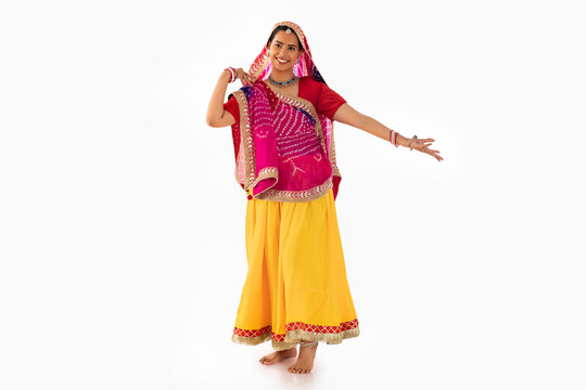 Portrait of Rajasthani woman dancing against white background