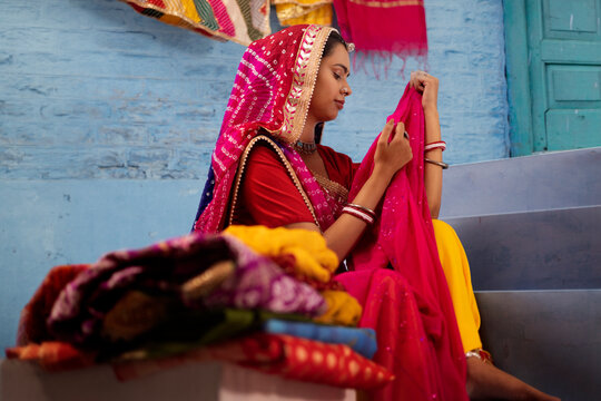  Rajasthani woman selling colourful local fabrics outside her house in Rajasthan