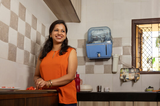 Smiling woman chopping vegetable in the kitchen