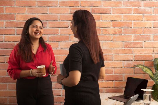 Two businesswomen talking during coffee break in office