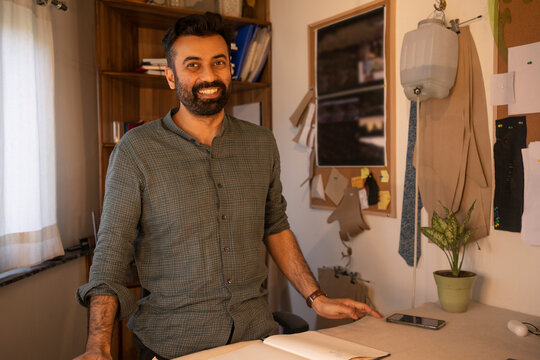 A male designer posing in his studio