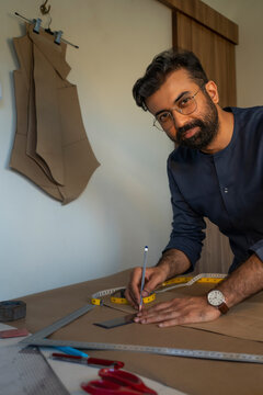 A male designer making patterns for a menswear collection in his studio 