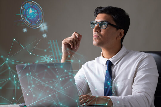 Businessman working on laptop computer with icons on virtual screen