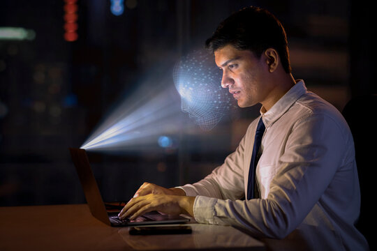 Young man using facial recognition technology with laptop