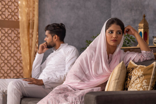Portrait of young Muslim couple ignoring each other after an argument in living room