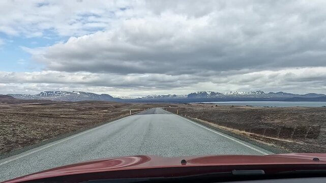 Dashcam POV on straight Route 36 toward Thingvellir with Lake Thingvallavatn right and snow mountains ahead, Iceland