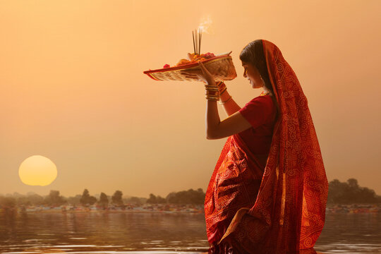 woman from Bihar offers prayers to the  sun  in the  early morning hours   during  Chhath Puja festival