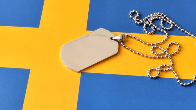 A dog tag on the Sweden flag, serving as a conceptual backdrop representing defense and preparation against attack. A dog tag on the Swedish flag as a background for your design