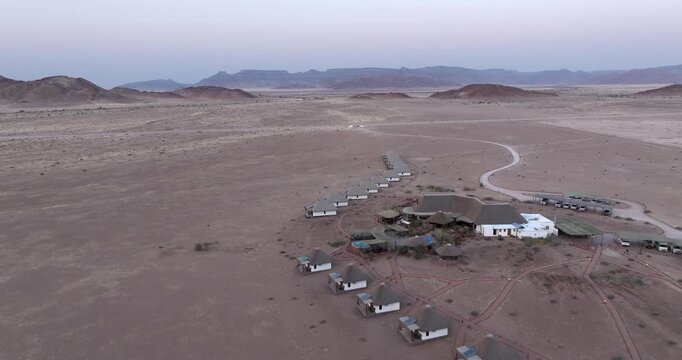 Aerial view of a desert lodge surrounded by vast arid plains near the Namib-Naukluft National Park, Namibia.