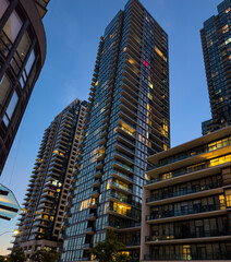 Modern Glass Residential Towers at Dusk, Contemporary apartment towers with illuminated windows during blue hour. © Moiz