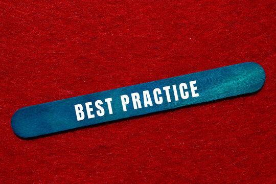 Blue stick displaying best practice text, representing business strategy, management, and quality standards on a red background