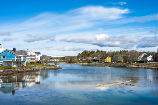 Views of houses along the river in Bronnoysund in Norway with blue sky and clouds during daytime