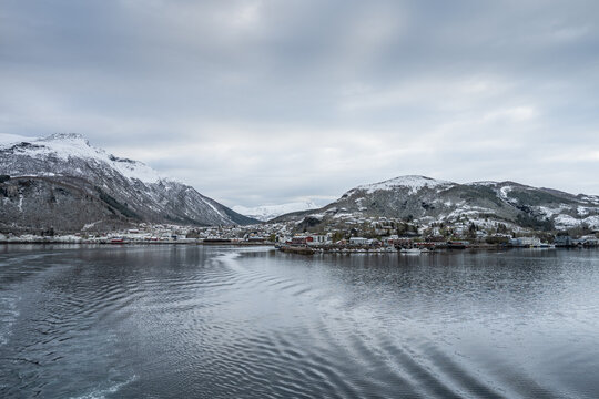 Scenic view of the small town of Ornes in Norway with mountains and calm water during the winter season