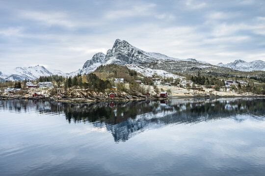 Scenic view of the small town of Ornes in Norway with mountains and calm water during the winter season with beatiful reflection