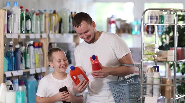  Young man with his son buyers chooses unclogging gel in household chemicals store