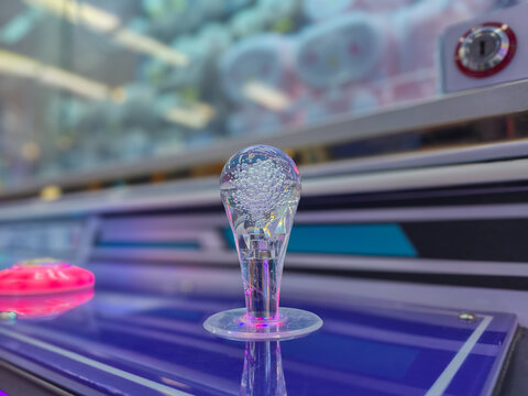 Claw Machine Joystick Close Up with Neon Glowing LED Lights in Arcade Game Room