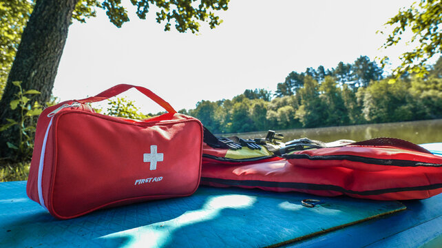 Red first aid kit and life vests ready for outdoor water adventure