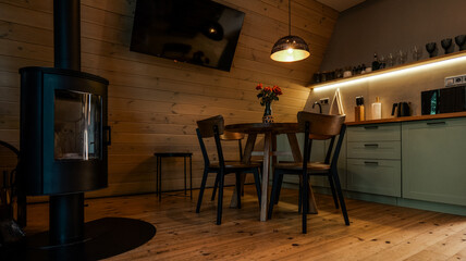 Obraz premium Cozy wooden cabin interior with dining area and modern kitchen
