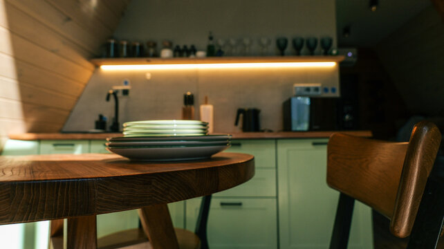 Cozy kitchen nook with wooden table and chairs, illuminated by warm ambient lighting