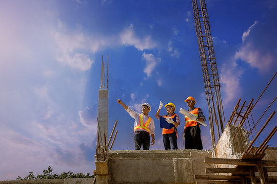 Structural engineer, architect and foreman worker with blueprints discuss, plan working for the outdoors building construction site. Construction collaboration concept
