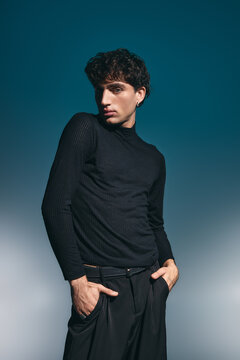 Handsome young man showcases stylish elegance in a modern, artistic setting.