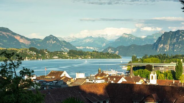 Time lapse of Lucerne cityscape with rolling clouds and shadows moving over Lake Lucerne against the Swiss Alps mountain peaks in Switzerland