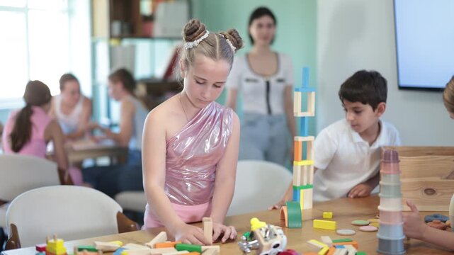 Engaged school kids building structures with educational toys during creative lessons inside playroom