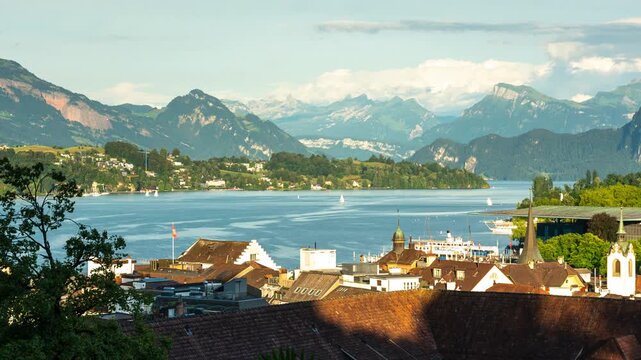 Lucerne skyline timelapse featuring passing boats on Lake Lucerne with the scenic Swiss Alps mountain range and moving clouds during a sunny summer day