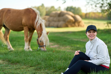 Obraz premium European woman caring for a horse in summer nature