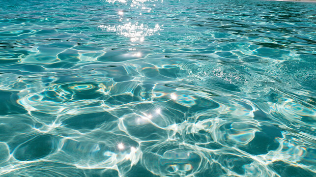 Clear turquoise sea water surface with bright sun reflections texture background