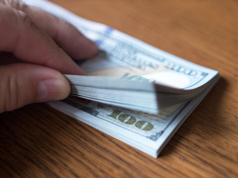 Counting Cash: Close-Up of Hand Holding Hundred Dollar Bills