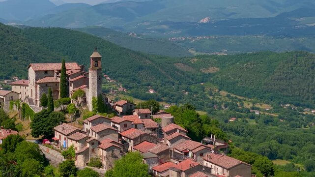 Cinematic Aerial Drone Flight Over Greccio Village Rooftops and Bell Tower Reveal Green Valley Rieti Lazio Italy Most Beautiful Villages Authentic Medieval Architecture 4K 70mm Look Travel Footage