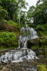Beautiful tropical waterfall cascading down mossy rocks in a dense green forest, La Palmita waterfall in La Azulita, Merida, Venezuela. © javier