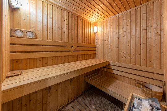 Cozy wooden sauna room interior. Traditional Finnish bath for relaxation, wellness, and spa therapy concept.