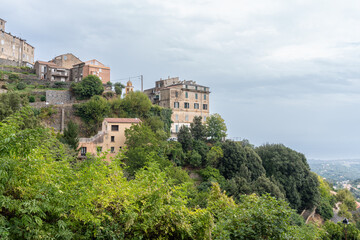 Fototapeta premium Cervione village buildings clinging Corsica hillside landscape