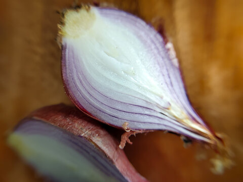 Extreme close up of sliced ​​red onion (Allium cepa) isolated on a wooden chopping board