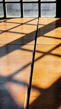 Vertical video: Shifting sunlight bathing wood, showing seam reflection with window grid shadows