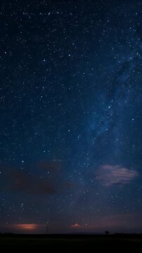 Vertical video: Drifting low cloud crossing plain at night, prompted by storm glow under Milky Way