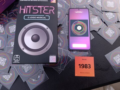 Hitster - Jogo de cartas e m&uacute;sica. O objetivo &eacute; simples: voc&ecirc; n&atilde;o precisa ser um especialista em m&uacute;sica, basta reconhecer os sucessos e organiz&aacute;-los em uma linha do tempo cronol&oacute;gica.