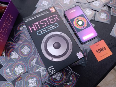 Hitster - Jogo de cartas e m&uacute;sica. O objetivo &eacute; simples: voc&ecirc; n&atilde;o precisa ser um especialista em m&uacute;sica, basta reconhecer os sucessos e organiz&aacute;-los em uma linha do tempo cronol&oacute;gica.