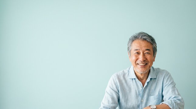 60代の日本人シニア男性を、淡いアクアカラー背景で爽やかに表現しています。
リネンシャツと自然な笑顔が、健康的で親しみやすいシニアライフを印象づけます。