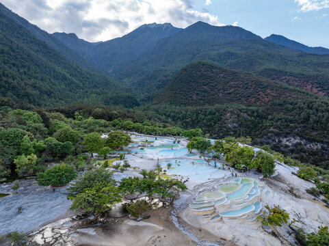 Bai Shui Tai terraced travertine pools surrounded by green mountains and forests in Yunnan