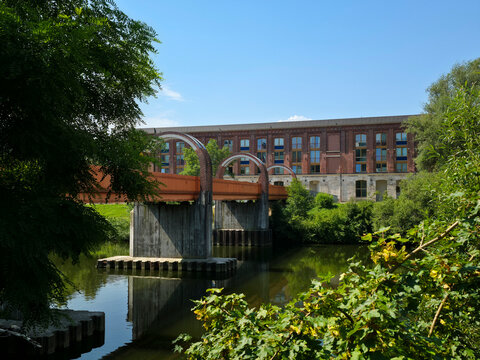 germany, elegant ottosteg footbridge connecting bruckenwasen park and old town above neckar river beside striking red brick architecture