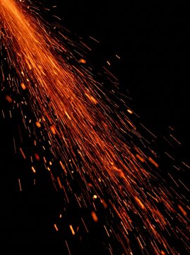 Fire sparks and glowing embers overlay flying on black background with motion trails