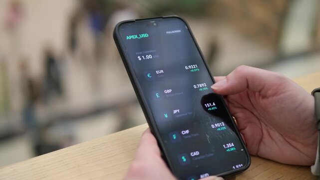 Hand scrolling through global currency exchange rates on a smartphone. EUR, GBP, JPY, and CNY rates visible. Ideal for forex, international business, and travel finance stock footage.